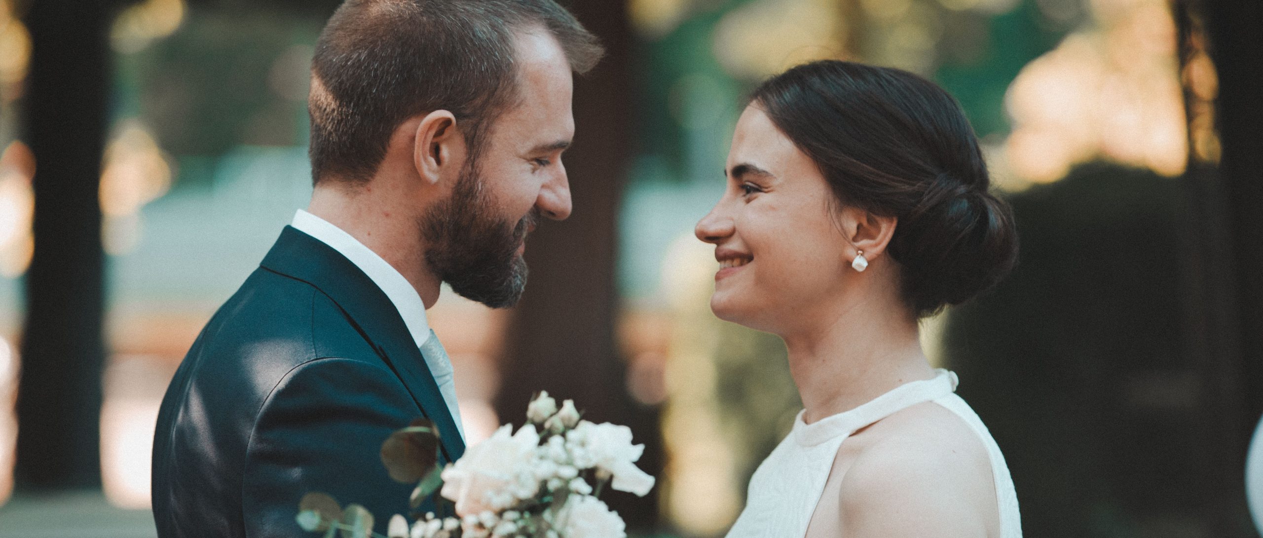 Couple de mariés face à face en riant dans un moment de complicité joyeux, séance photo mariage