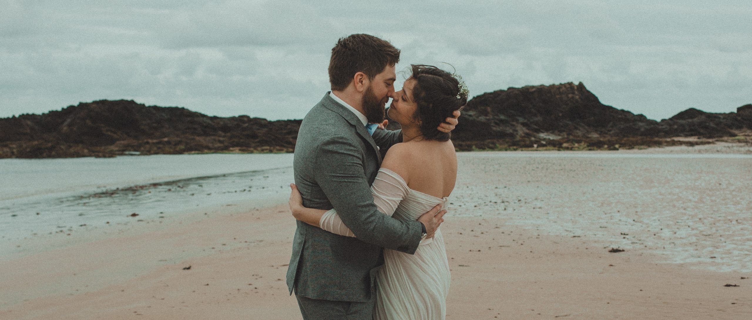 Couple de mariés face à face souriants devant un décor architectural, séance photo mariage