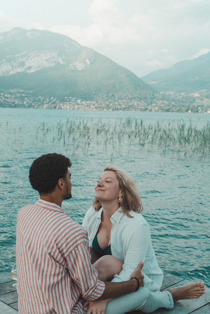 Couple mixte riant ensemble au bord de l'eau, photo de couple naturelle et joyeuse